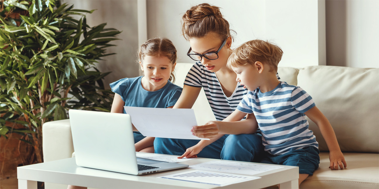 Busy woman working from home with kids sitting nearby